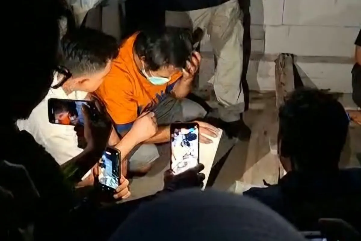 Tersangka DBM memperagakan salah satu adegan dalam pra rekonstruksi kasus pembunuhan terhadap istri siri dan anaknya di Kota Madiun, Jawa Timur, Selasa (27/10/2026) malam